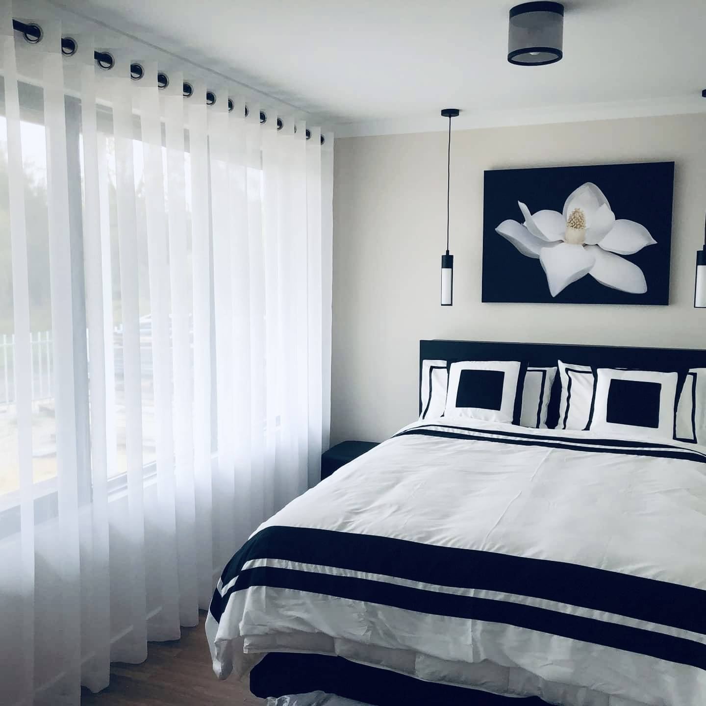 White eyelet sheer curtains filtering daylight in a bedroom