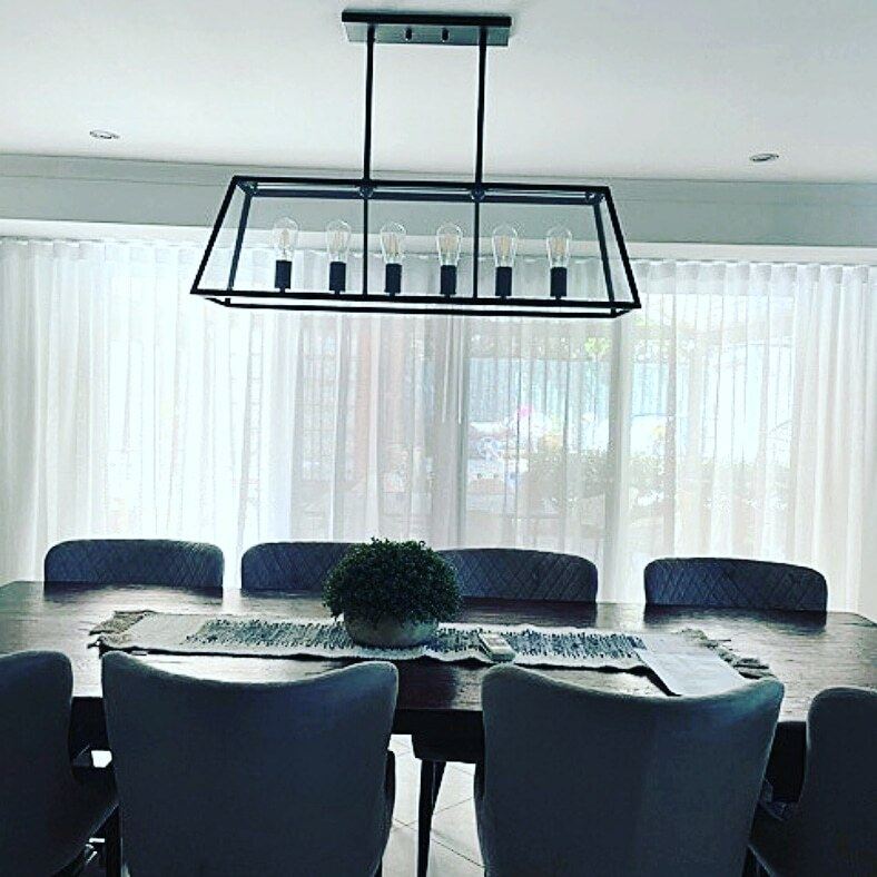 White sheer curtains behind a dining table
